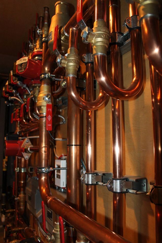 Emergency plumber in Manchester repairing copper pipework under a sink